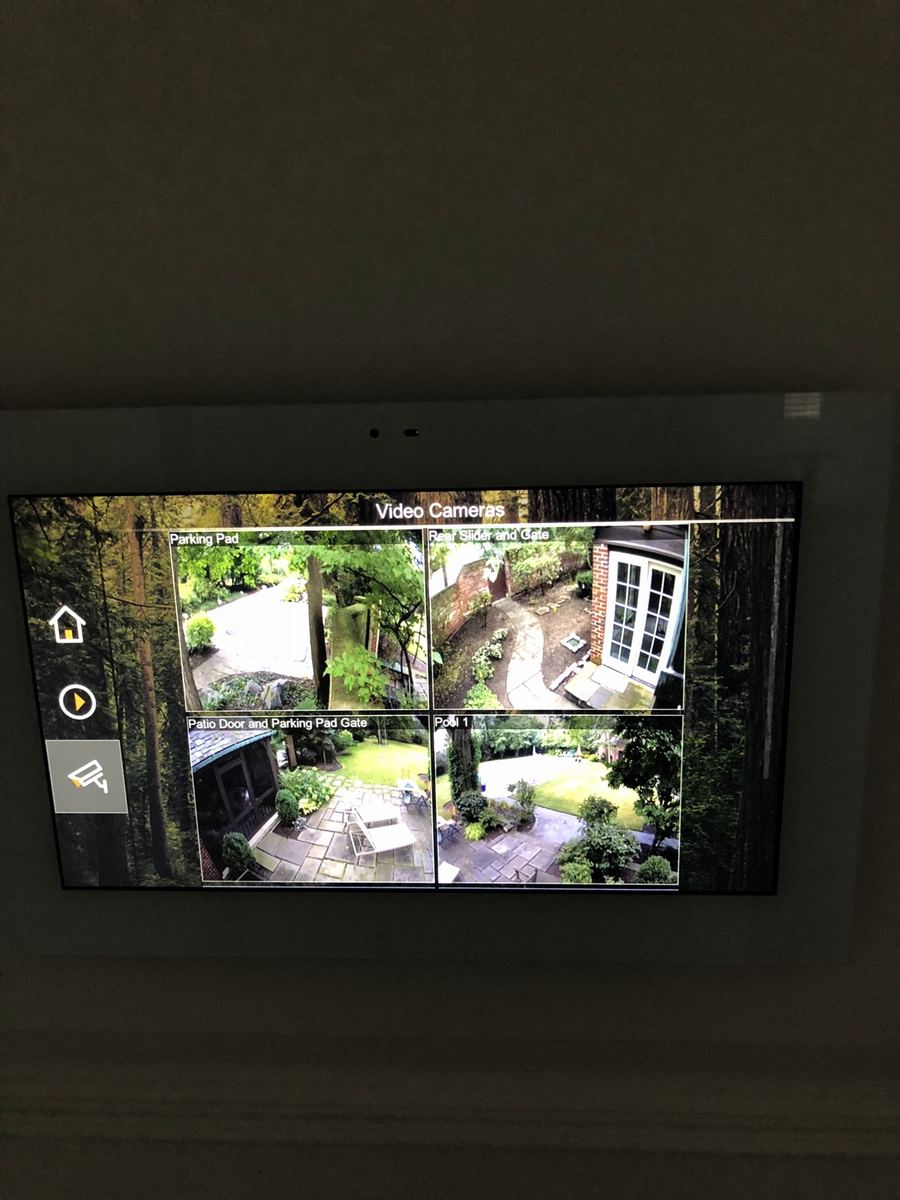 Touchscreen control panel showing live camera views from around the house