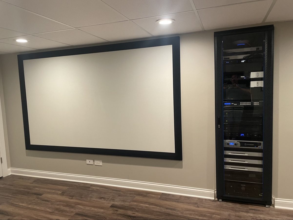 Home theater with large screen and rows of recliner seating