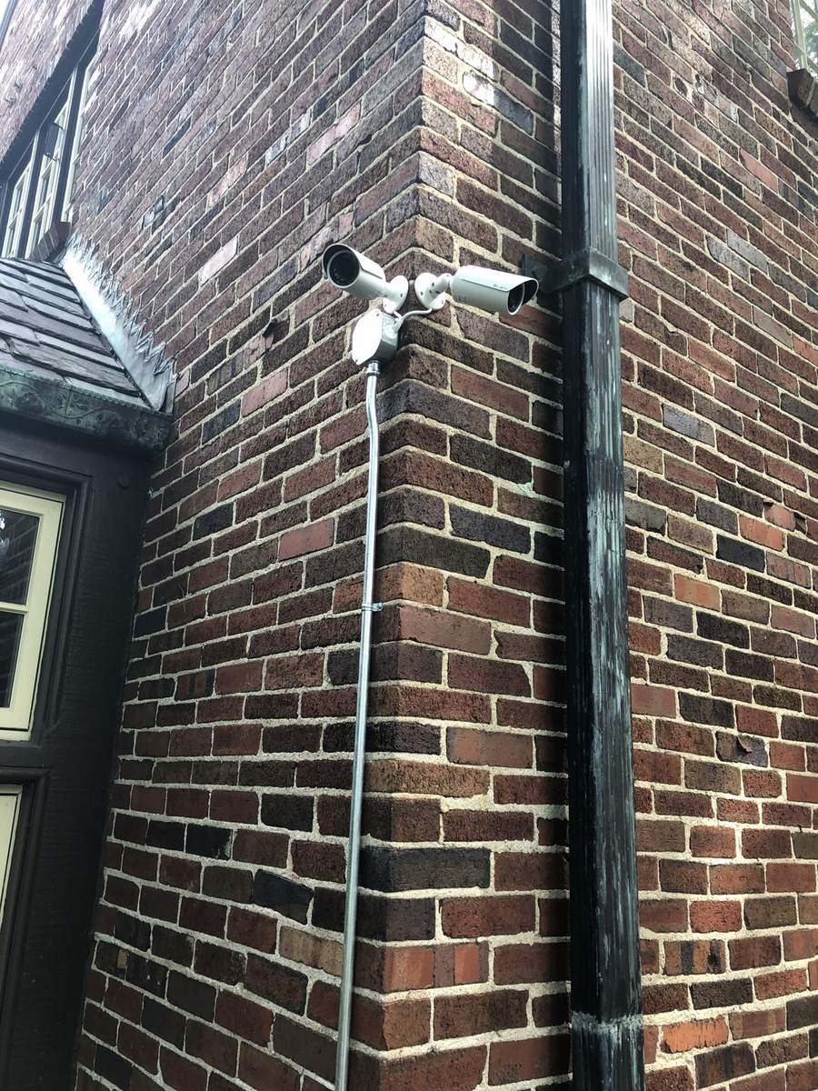 Two bullet security cameras mounted on the brick corner of a commercial building