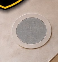 Round in-ceiling speaker installed flush in a ceiling